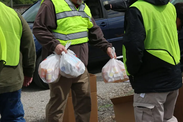 volunteers in green vests collection old drugs for proper disposal