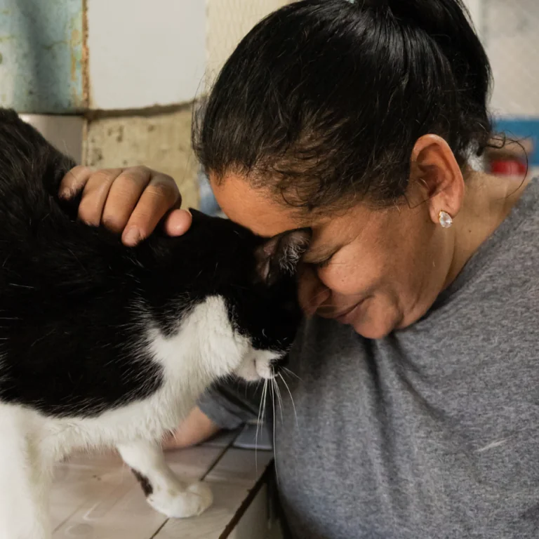 woman petting a black and white cat