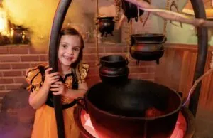 little girl standing next to cauldron in Leeward Manor