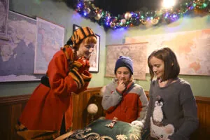 Elf with kids in santa's cottage